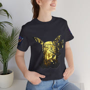 Person wearing a Forest t-shirt with a gold butterfly design, standing indoors next to a plant.