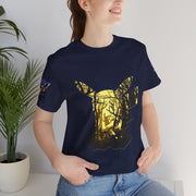 Person wearing a navy blue t-shirt with a gold deer design, standing indoors next to a plant.
